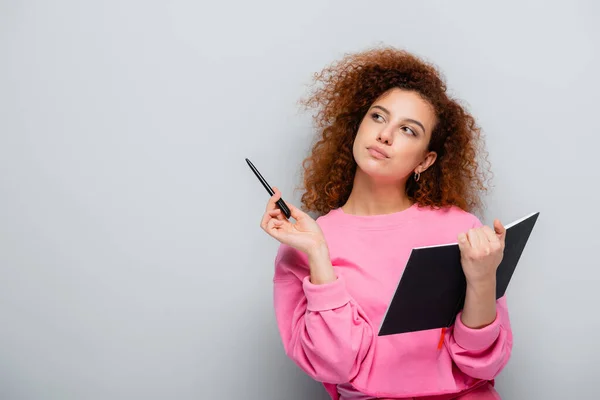 Thoughtful Woman Looking Away While Holding Pen Notebook Grey Background — Stock Photo, Image