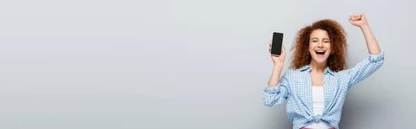 Joyful Woman Showing Success Gesture While Holding Cellphone Blank Screen — Stock Photo, Image