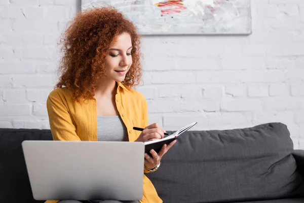 Pretty Teleworker Writing Notebook While Sitting Couch Laptop Stock Photo