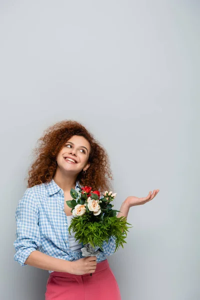 Fröhliche Frau Die Aufblickt Und Mit Der Hand Zeigt Während — Stockfoto