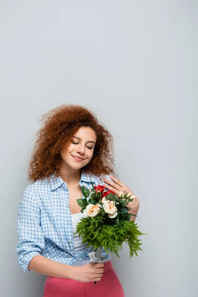 Mulher Satisfeita Com Cabelos Cacheados Segurando Flores Fundo Cinza — Fotografia de Stock