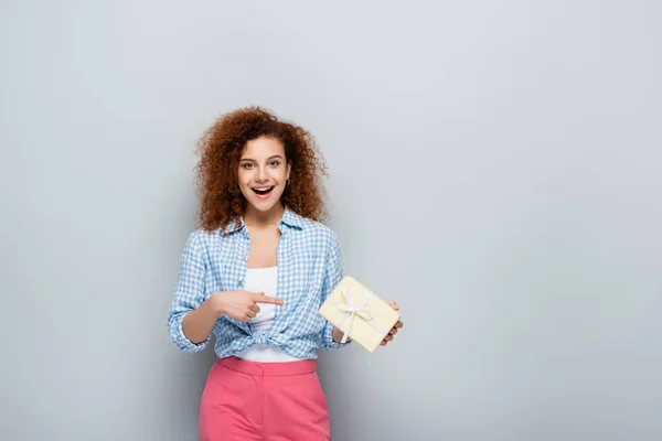 Glad Kvinna Pekar Presentförpackning Medan Tittar Kameran Grå Bakgrund — Stockfoto