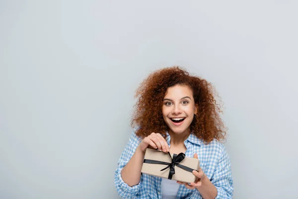Excited Woman Looking Camera While Opening Present Isolated Grey — Stock Photo, Image