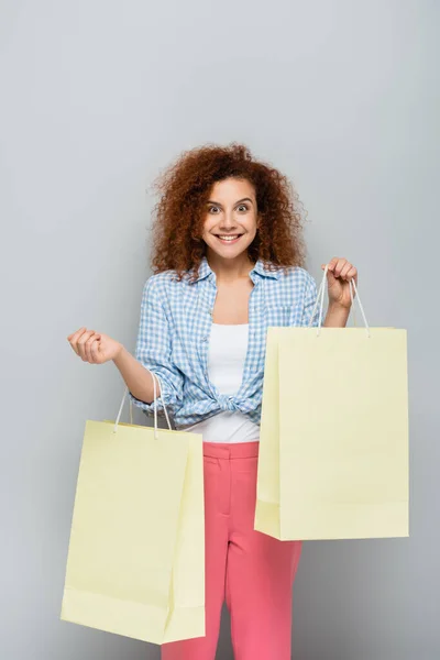 Cheerful Woman Looking Camera While Holding Shopping Bags Grey Background — Stock Photo, Image