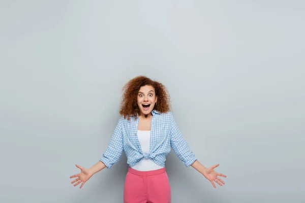 Verbaasd Vrouw Geruite Shirt Staan Met Open Armen Grijze Achtergrond — Stockfoto