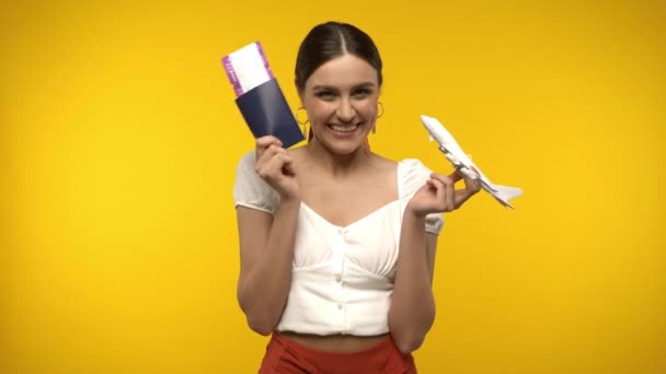 Mulher Portadora Passaporte Bilhete Aéreo Avião Brinquedo Isolado Amarelo — Vídeo de Stock