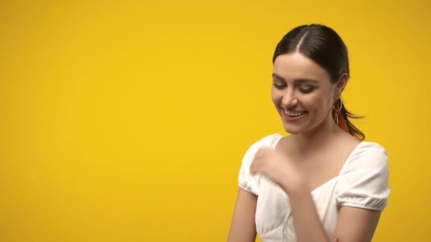 ポジティブなブルネット女性見ますカメラ絶縁上の黄色 — ストック動画