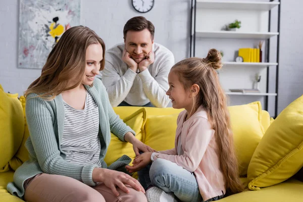 Chica Sonriente Sentada Cerca Madre Padre Borroso Sala Estar — Foto de Stock