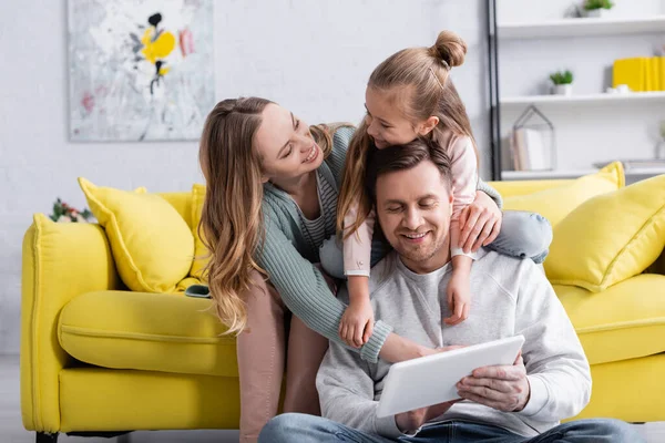 Leende Kvinna Tittar Dotter Kramar Far Med Digital Tablett — Stockfoto