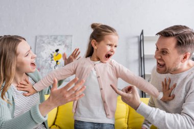 Yelling child pushing away quarreling parents  clipart