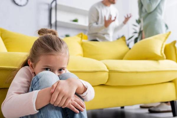 Verängstigtes Kind Blickt Kamera Während Eltern Sich Auf Verschwommenem Hintergrund — Stockfoto