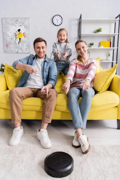 Familia Sonriente Apuntando Aspiradora Robótica —  Fotos de Stock