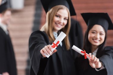 Bulanık geçmişi olan ırklar arası öğrencilerin ellerinde diplomalar 