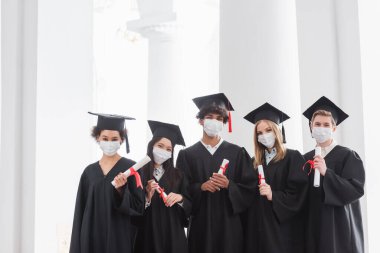 Tıp maskeli çok ırklı mezunların diplomaları var. 