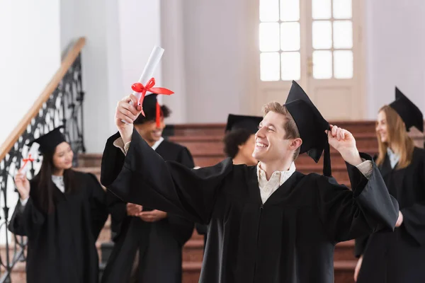 Feliz Soltero Mirando Diploma Cerca Estudiantes Multiétnicos —  Fotos de Stock