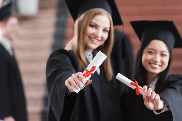 Diplomy Rukou Různých Studentů Rozmazaném Pozadí — Stock fotografie