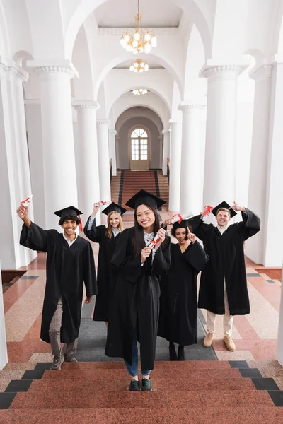 Usmívající Asijský Absolvent Držící Diplom Schodech Blízkosti Přátel Univerzitě — Stock fotografie