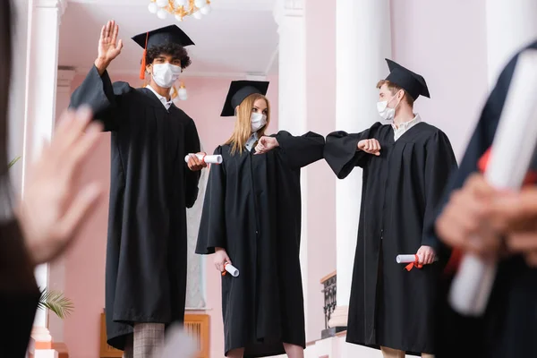 Africano Americano Graduado Máscara Médica Acenando Mão Perto Amigos Fazendo — Fotografia de Stock