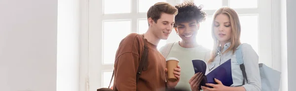 Studenti Interrazziali Con Caffè Andare Taccuino Piedi Vicino Alla Finestra — Foto Stock