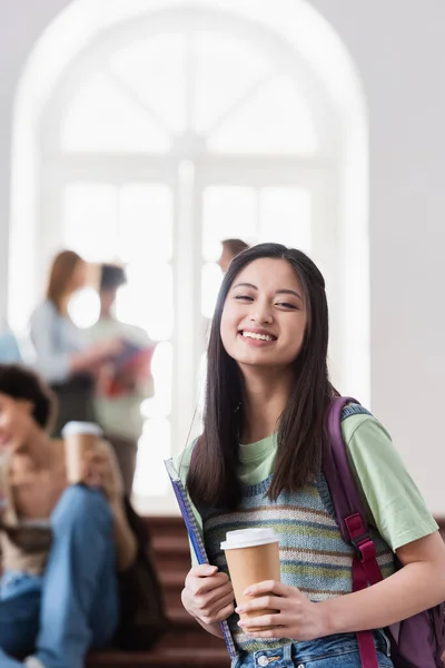 Smilende Asiatisk Student Med Papirkopp Notatbok Som Ser Kamera – stockfoto