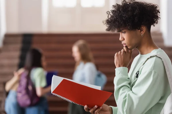 Vista Lateral Del Estudiante Afroamericano Enfocado Mirando Cuaderno —  Fotos de Stock
