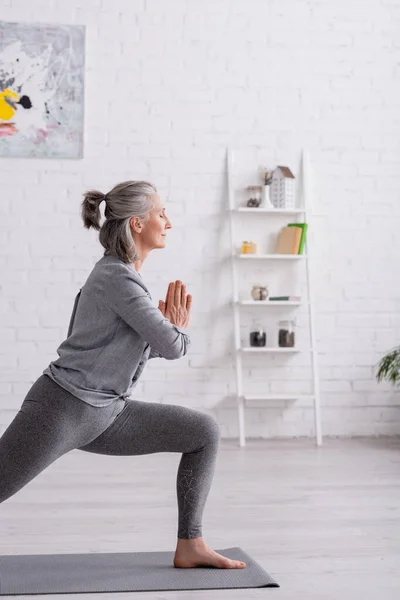 Dua Eden Elleri Olan Orta Yaşlı Bir Kadın Evde Yoga — Stok fotoğraf