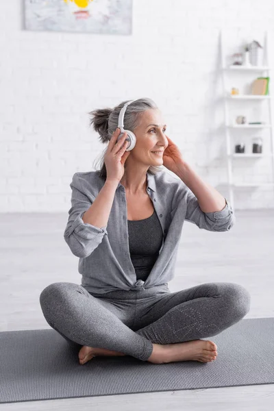 Happy Middle Aged Woman Wireless Headphones Sitting Lotus Pose Yoga — Stock Photo, Image