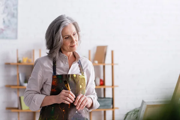 Middle Aged Artist Apron Spills Holding Paintbrush Home — Stock Photo, Image