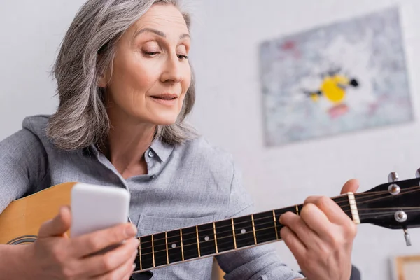 Mature Woman Grey Hair Holding Blurred Smartphone While Learning Play — Stock Photo, Image