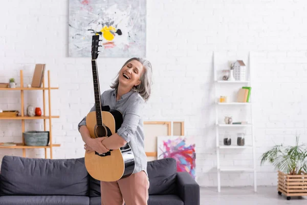 Joyful Mature Woman Grey Hair Standing Acoustic Guitar Couch Living — Stock Photo, Image