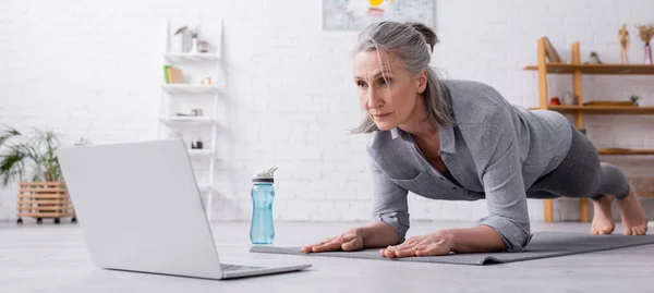 Volwassen Vrouw Doen Plank Kijken Naar Laptop Banner — Stockfoto