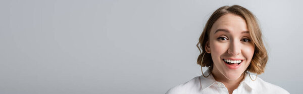 возбужденный избыточный вес женщина в белой рубашке, глядя на камеру изолированы на серый, баннер