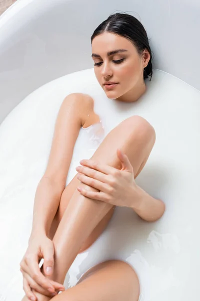 Seductive Woman Touching Leg While Bathing Milk — Stock Photo, Image