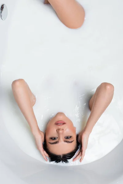 Sensual Mujer Tocando Cabello Mirando Cámara Mientras Relaja Baño Lechoso — Foto de Stock