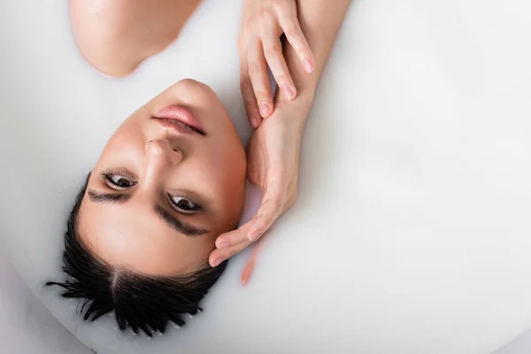 Seductive Woman Milk Bath Holding Hand Face Looking Camera — Stock Photo, Image