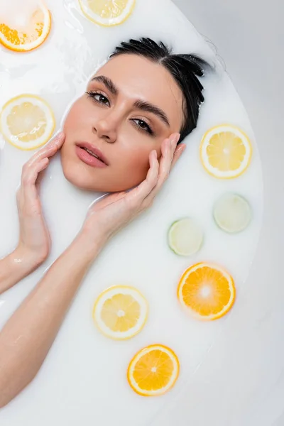 Mujer Joven Tocando Cara Mirando Cámara Baño Leche Con Rodajas — Foto de Stock