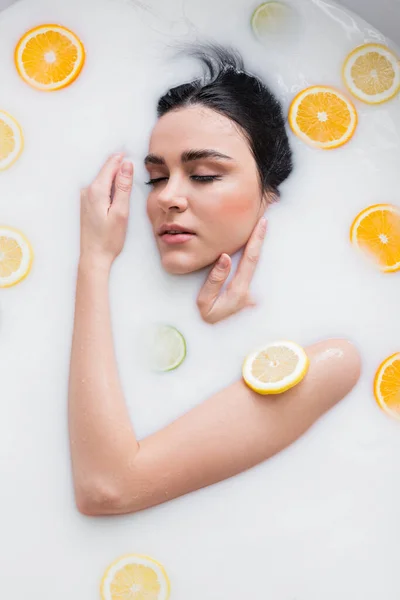 Ung Sensuell Kvinna Som Tar Mjölkbad Med Skivade Citrusfrukter — Stockfoto