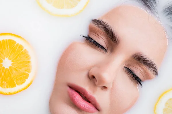 Vista Cerca Cara Femenina Baño Leche Con Cítricos Rodajas — Foto de Stock