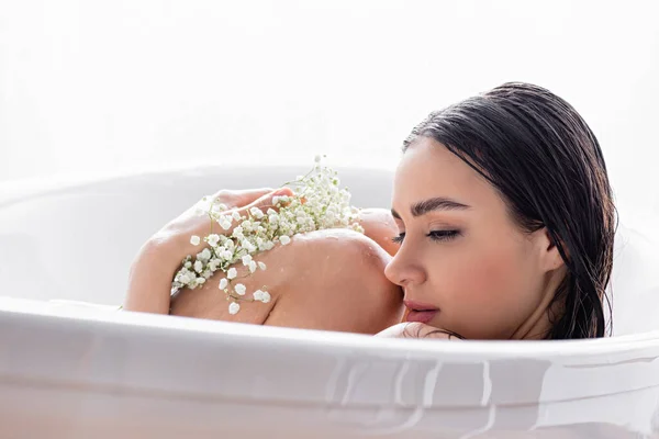 漂亮的年轻女子坐在浴缸里 开着吉普赛花 — 图库照片