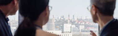 Ofis penceresi yakınındaki şehir manzarasına bakan bulanık iş adamları, afiş 