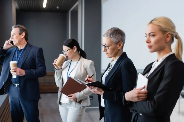 Businesswoman Writing Notebook Interracial Colleagues Takeaway Drink — Stock Photo, Image