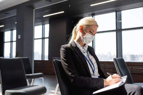 Affärskvinna Medicinsk Mask Skriva Anteckningsbok När Sitter Konferensrummet — Stockfoto