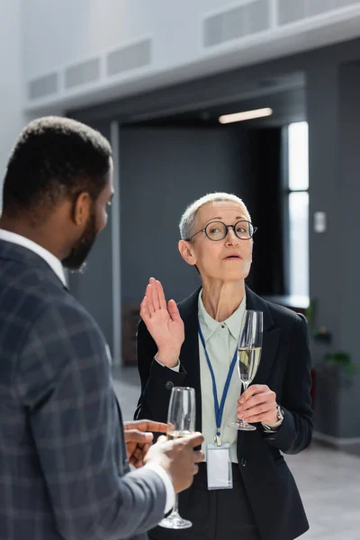 Mujer Negocios Mediana Edad Gesticulando Mientras Habla Con Colega Afroamericano — Foto de Stock