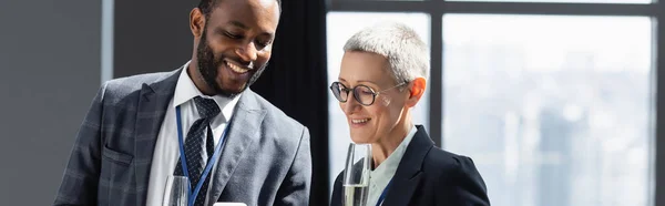 Sonriente Gente Negocios Multiétnicos Sonriendo Mientras Habla Oficina Pancarta —  Fotos de Stock