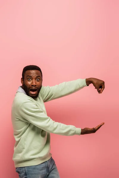 Scared African American Man Holding Something Isolated Pink — Stock Photo, Image