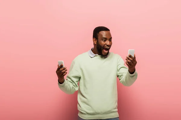 분홍색 배경으로 스마트폰을 아프리카계 — 스톡 사진