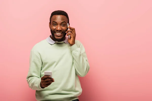 Sonriente Afroamericano Hombre Sosteniendo Teléfono Inteligente Durante Conversación Sobre Fondo — Foto de Stock