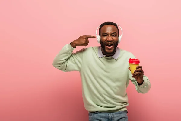 Alegre Hombre Afroamericano Apuntando Los Auriculares Sosteniendo Café Para Sobre — Foto de Stock