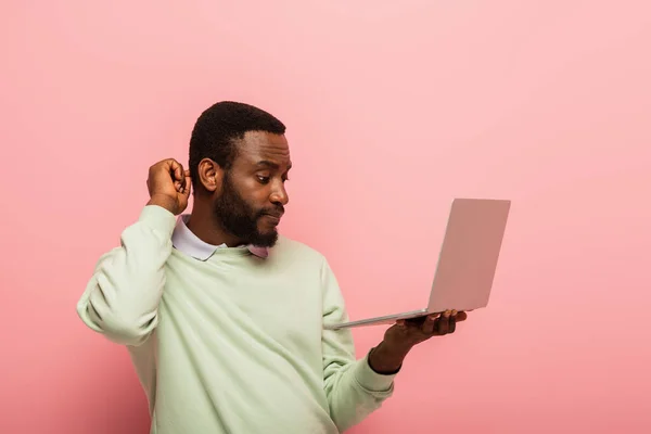 Thoughtful African American Man Touching Head While Looking Laptop Pink — Stock Photo, Image