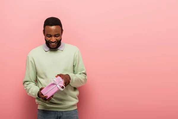 Hombre Afroamericano Feliz Mirando Presente Sobre Fondo Rosa — Foto de Stock